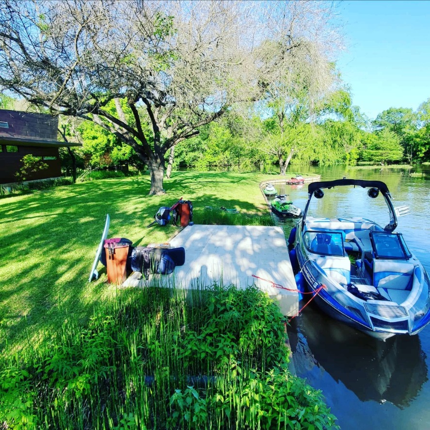 Wake boat tied to a private dock on Lake Austin